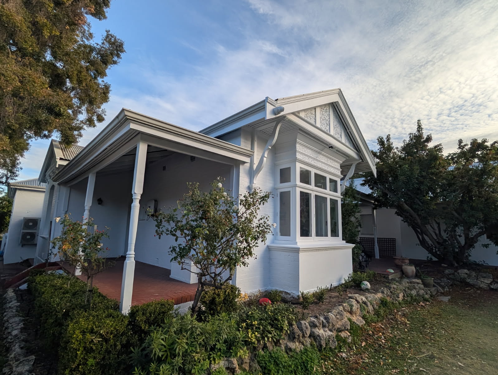 Repainted heritage cottage exterior with crisp white trim and bay window